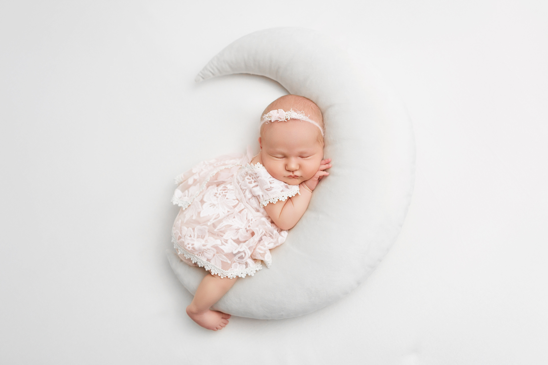 Newborn-baby-peacefully-sleeping-on-moon-during-a-professional-studio-session