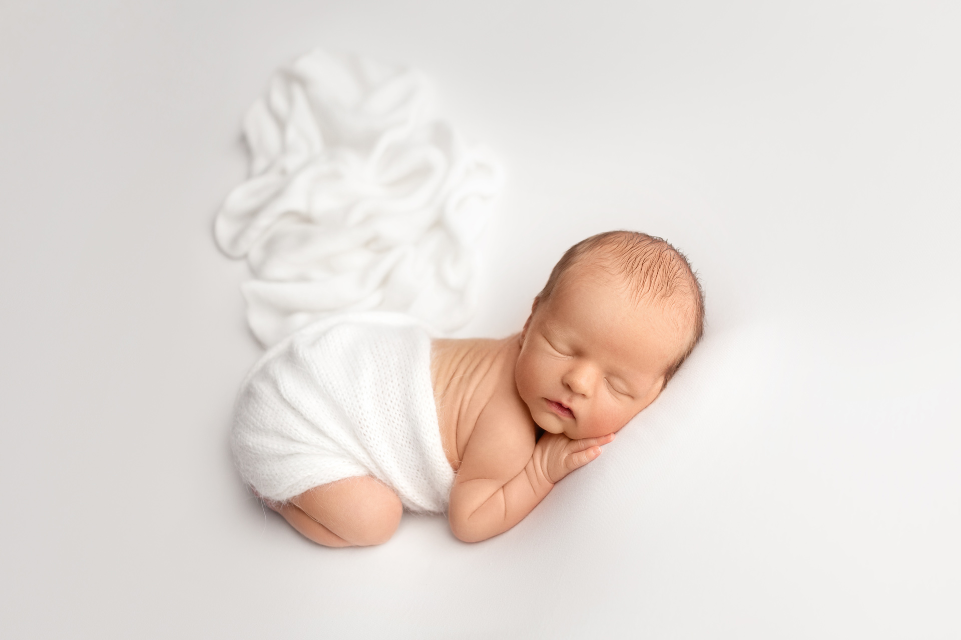 Sleeping-newborn-baby-wrapped-safely-during-a-newborn-photography-session